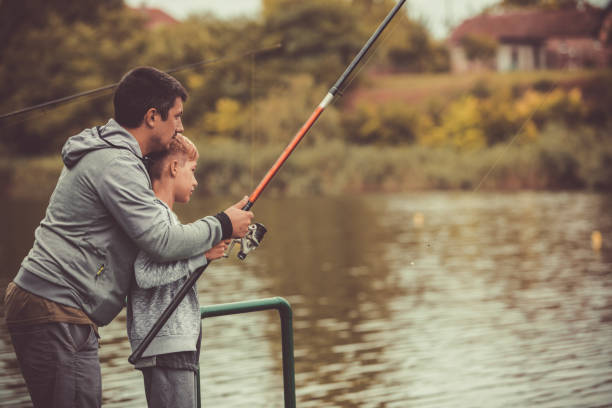 istock Three quarter length shot of dad helping blond boy to fish 1265104025