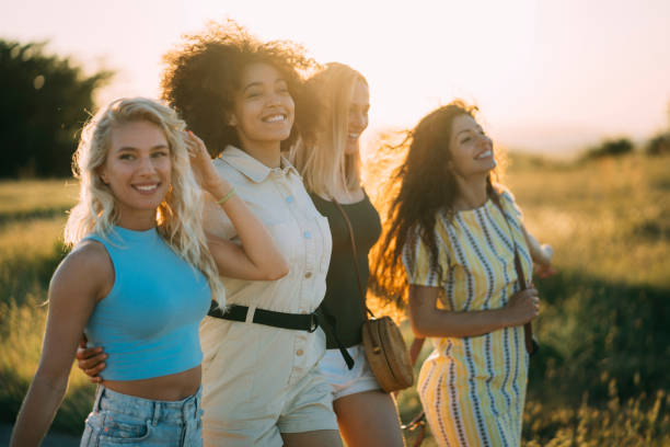 istock Female friends walking at sunset and having fun 1265104904