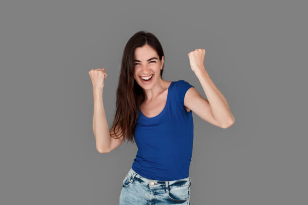 istock Young girl studio standing isolated on grey hands in fists up successful 1265105178
