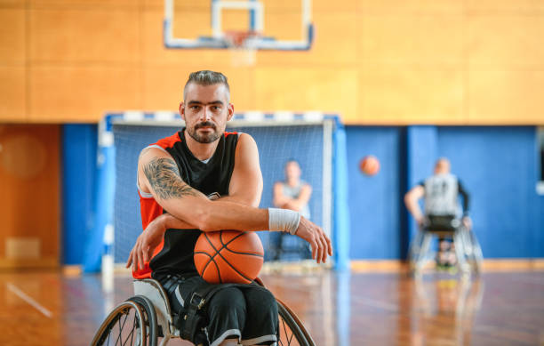 retrato de confident male wheelchair basketball player - physical impairment smiling front view looking at camera fotografías e imágenes de stock