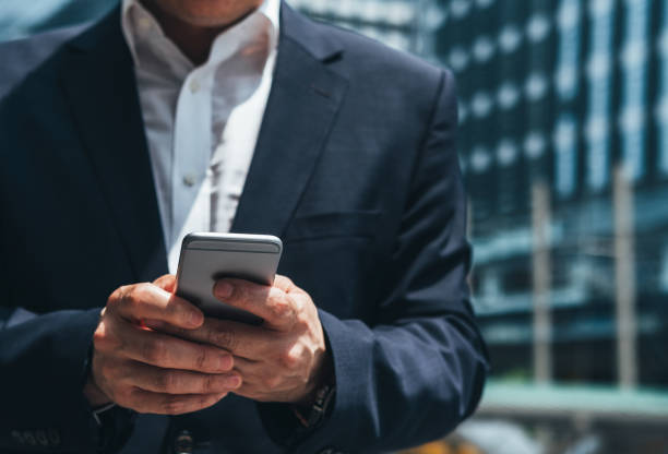 istock Unrecognizable business man using phone outside office stock photo 1265109227