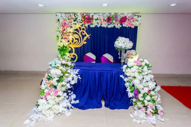 Artificial colorful paper flowers with navy-blue color based wedding stage decoration.