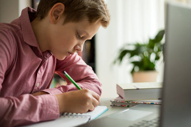 istock Teenage boy using laptop for homework online school education 1265113449