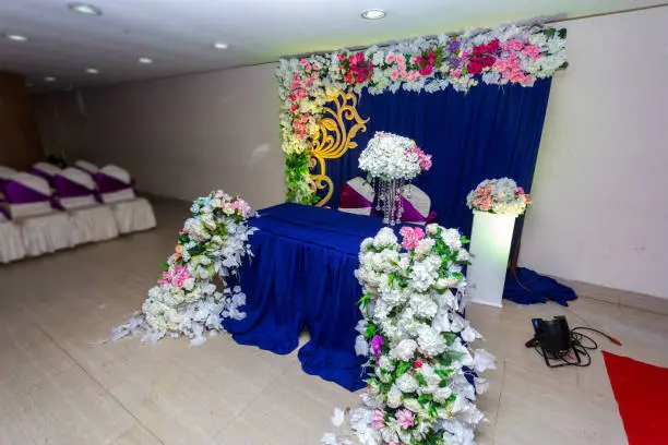 Artificial colorful paper flowers with navy-blue color based wedding stage decoration.