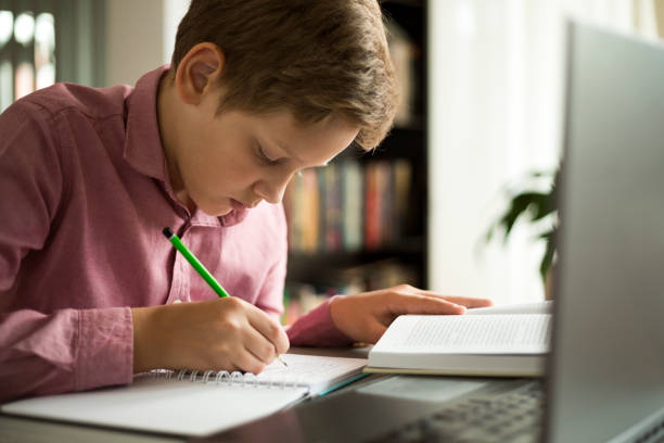 istock Teenage boy using laptop for homework online school education 1265114352