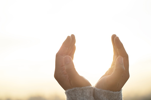 Women raise their hands to ask for blessing from God.