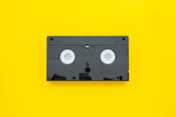 istock Old VHS video cassette tape on yellow background 1265115907