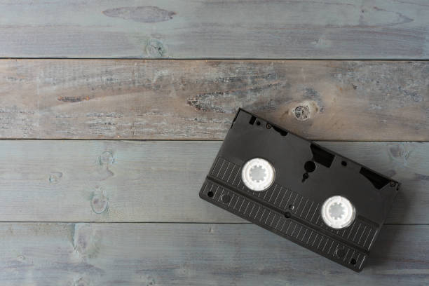 istock Old VHS video cassette tape on wooden board 1265116059