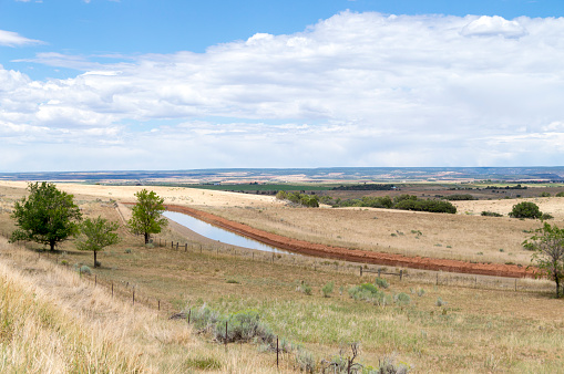 This irrigation ditch winds through cultivated farmland in southwestern Colorado, USA.  This ditch provides water to crops in this largely arid environment.