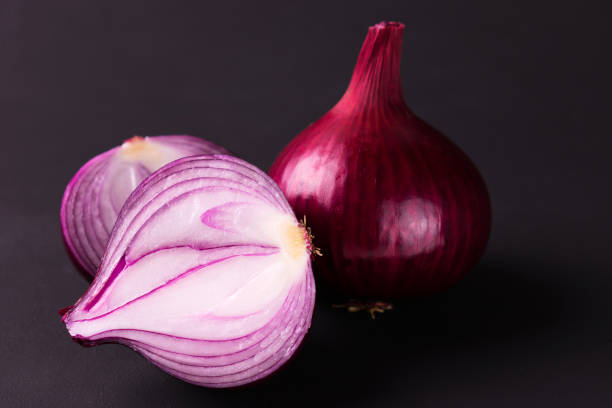 istock Red onion in a cut on a black background. 1265133120