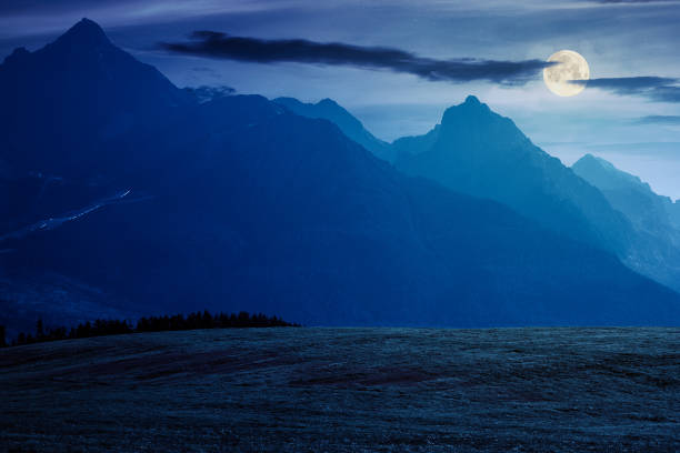 countryside summer landscape. rural fields rolling in to the distant high tatra mountain ridge in slovakia. great scenery in full moon light