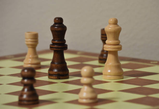 istock Chess board with black and white figures. Two queens in focus 1265140360
