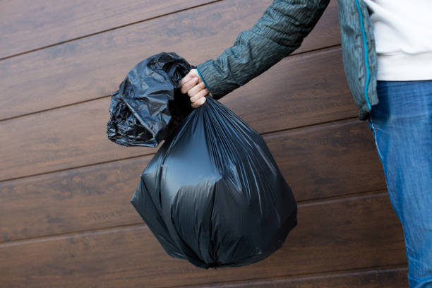 el tipo sostiene una bolsa de basura negra de cerca - garbage bag fotografías e imágenes de stock