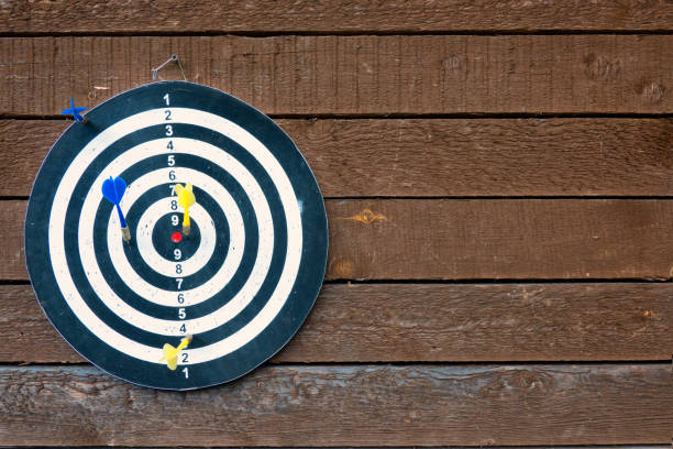 istock The dart board hangs on an old brown wooden wall. Background. Texture. 1265144776