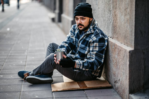 istock Homeless man sitting and begging for help 1265144833