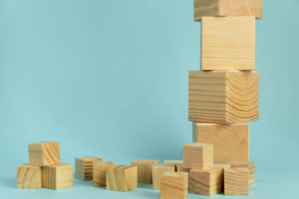 istock Construction of wooden cubes on blue background with copy space. Mockup composition for design 1265149385