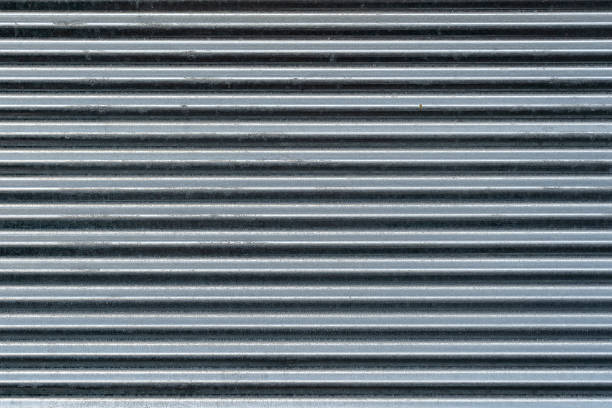 istock Metal wall texture, background. Sheet of ribbed galvanized metal for building structures. It is used for covering roofs for construction of fences 1265150361