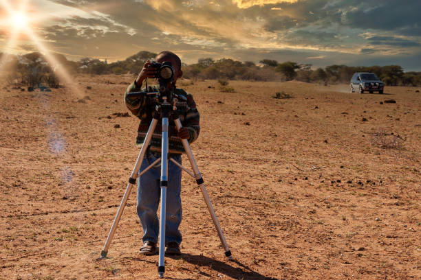 afrikanische skid, die fotos mit einer kamera auf einem stativ macht - photographer camera tripod paparazzi photographer stock-fotos und bilder