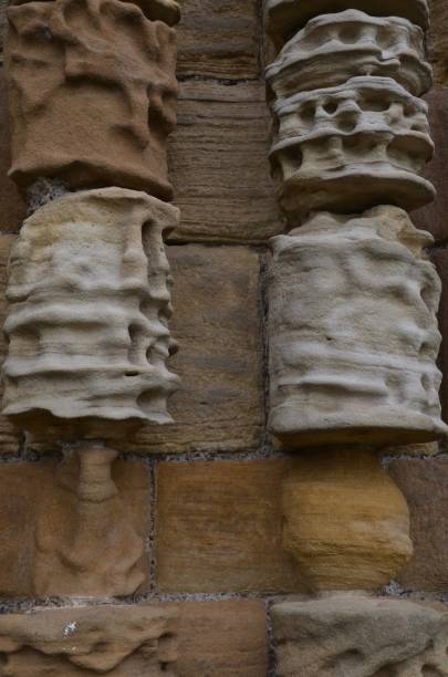 Stone wall background with circular stones and flat stones. Wavy textures in creams and sandstone colours