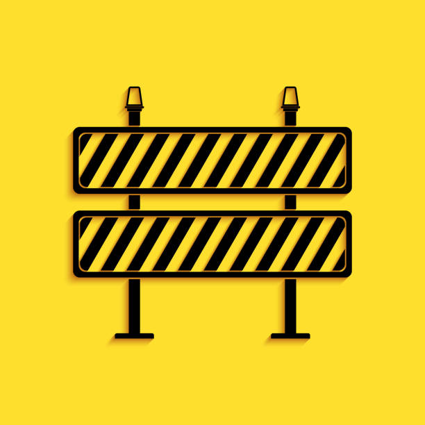 istock Black Road barrier icon isolated on yellow background. Restricted area which are in under construction processes. Fence of building or repair works sign. Long shadow style. Vector 1265153405
