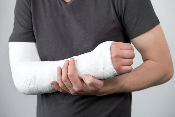 istock Closeup view of man's hand with plaster cast on a white wall background. 1265154629