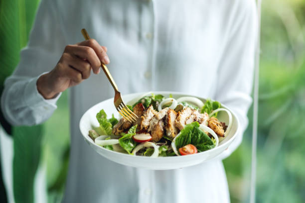 istock a woman holding and eating chicken salad 1265154681