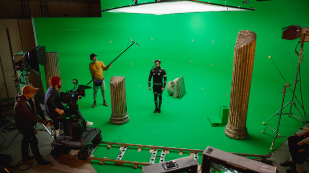In the Big Film Studio Professional Crew Shooting Blockbuster Movie. Director Commands Cameraman to Start shooting Green Screen CGI Scene with Actor Wearing Motion Capture Suit and Head Rig In the Big Film Studio Professional Crew Shooting Blockbuster Movie. Director Commands Cameraman to Start shooting Green Screen CGI Scene with Actor Wearing Motion Capture Suit and Head Rig chroma key stock pictures, royalty-free photos & images