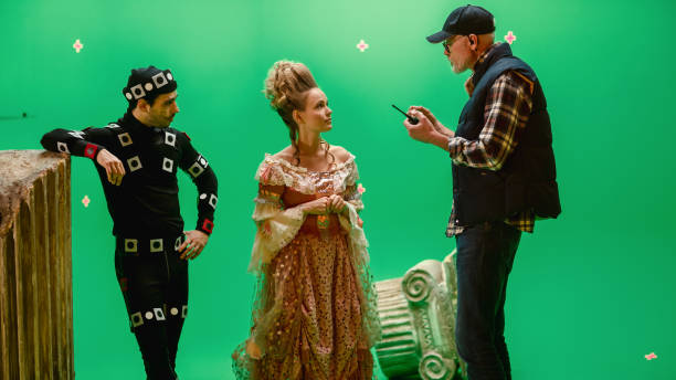 na okres costume drama film set: beautiful smiling aktorka sobie renaissance dress i aktor sobie motion capture suit s�łuchać reżyser filmu wyjaśniając jej scene context. - narrative cinema zdjęcia i obrazy z banku zdjęć