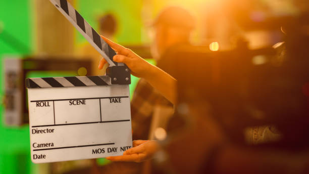 istock Close up Shot On Film Studio Set Young Camera Assistant Holds Empty Clapperboard. In the Background Director Shooting Green Screen Scene. History Costume Drama Movie. 1265157303