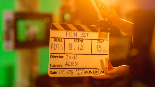 istock On Film Studio Set Young Camera Assistant Holds Clapperboard with Written Information on it. In the Background Director Shooting Green Screen Scene. History Costume Drama Movie. Close up Shot. 1265157324