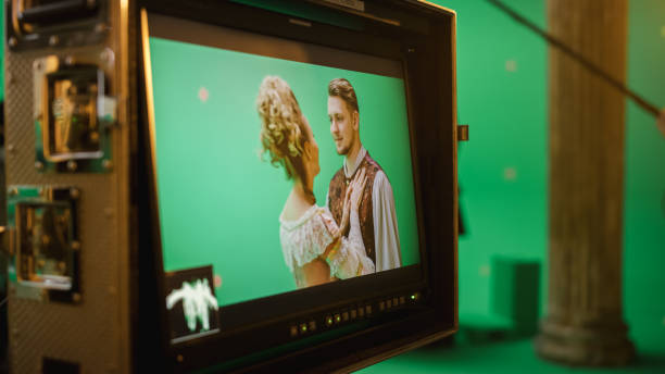 istock On Set Display Showing: Green Screen Scene with Two Actors Talented Wearing Renaissance Costumes Doing Romantic Drama Dialogue. Film Studio Professional Crew Shooting Historical Costume Drama Movie 1265157568
