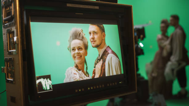 istock On Set Display Showing: Green Screen Scene with Two Actors Talented Wearing Renaissance Costumes Doing Romantic Drama Dialogue. Film Studio Professional Crew Shooting Historical Costume Drama Movie 1265157651