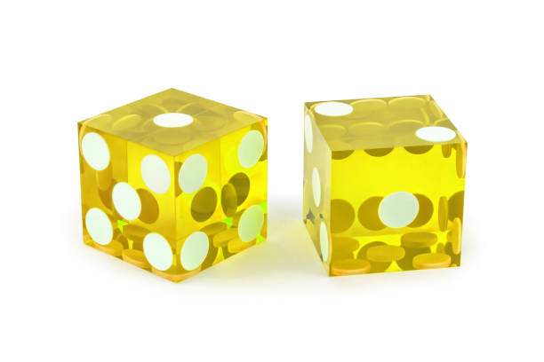 istock Two yellow professional game dice closeup isolated on a white background / one and two with a light shadow. 1265159082