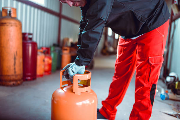 istock Male Worker Taking Small Gas Cylinder To Be Refilled 1265159128