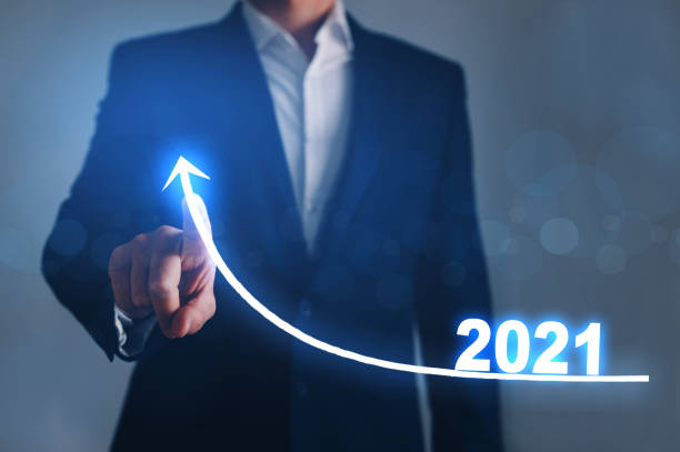 istock Businessman pointing arrow graph corporate future growth year 2021. 1265159215