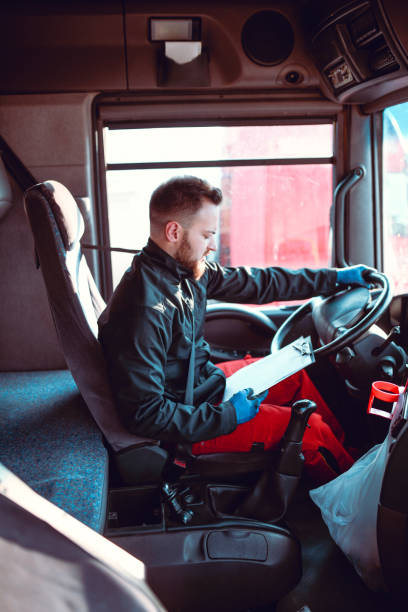 istock Tanker Truck Driver Examining Route Schedule On Notepad 1265159256