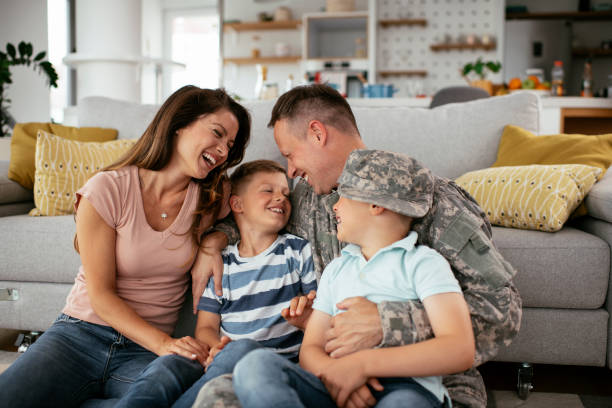 Soldier and his wife enjoying at home with children. Happy soldier sitting on the floor with his family. Soldier and his wife enjoying at home with children. patriotic man stock pictures, royalty-free photos & images