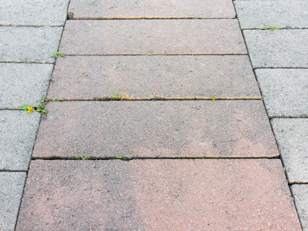 istock Decorative colorful sidewalk pavement. Tiled floor with grey tiles crossed by a diagonal double stripe of red tiles viewed at a low angle, full frame background pattern 1265160652