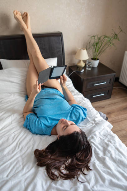 istock woman reading electronic book in bed. 1265161911