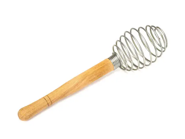 Houseware: steel whisk with wooden handle isolated on a white background