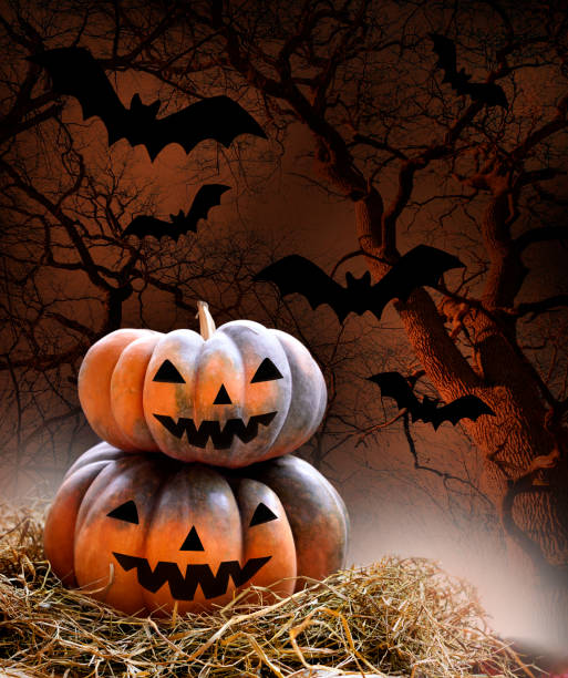 istock Pumpkins on hey on dark background with bats. Halloween concept 1265167264
