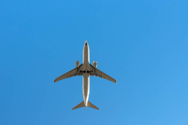 istock Passenger airplane flying on blue sky, low angle view 1265167273