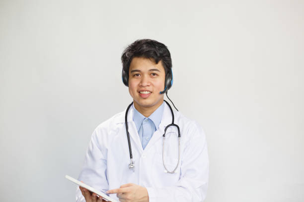 istock Young asian doctor with stethoscope talking with patient on white background 1265168301