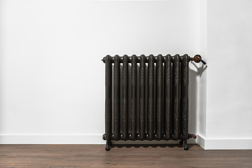 A vintage heat radiator in a white wall