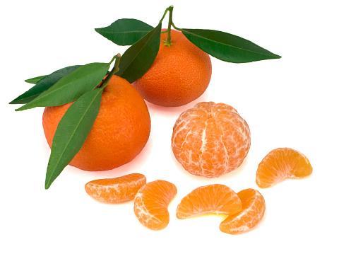 Ripe mandarins with leaves close-up on a white background.