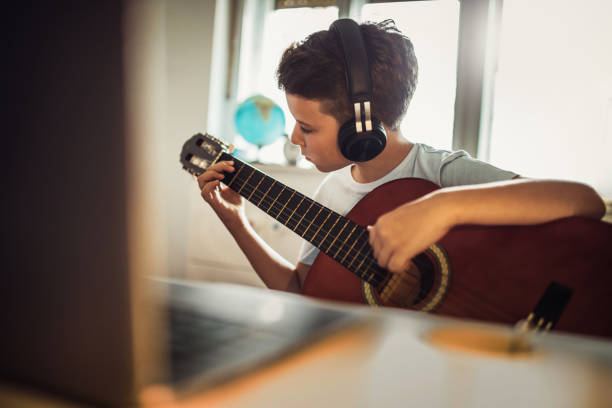 istock COVID 19 little boy  playing guitar in his room 1265170338