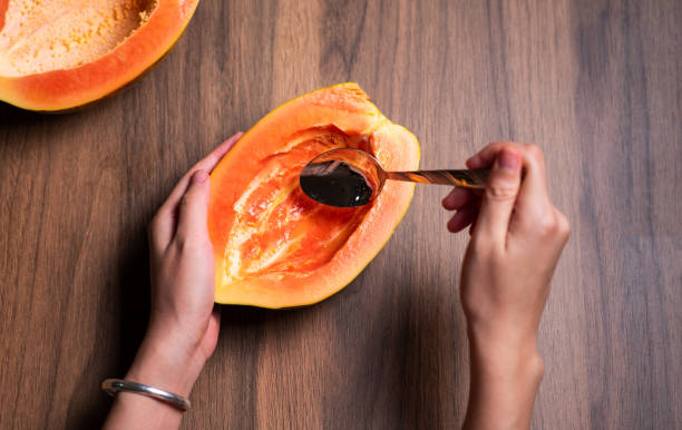istock Female eating papaya fruit with a spoon top view 1265172001