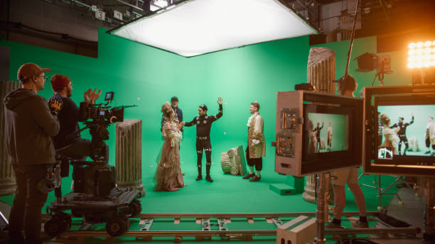 istock Film Studio Set: Shooting Green Screen Scene with Two Talented Actors Wearing Renaissance Clothes Talking, Director Finishes Scene, Celebrates Success, Embraces Actors. Period Drama Movie Backstage 1265173154