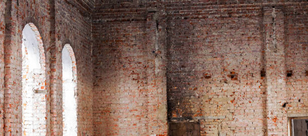 istock Old building falling apart with broken windows, walls covered with cracks and scratches 1265174315