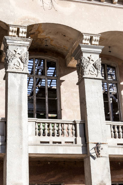 istock Old building falling apart with broken windows, walls covered with cracks and scratches 1265174343